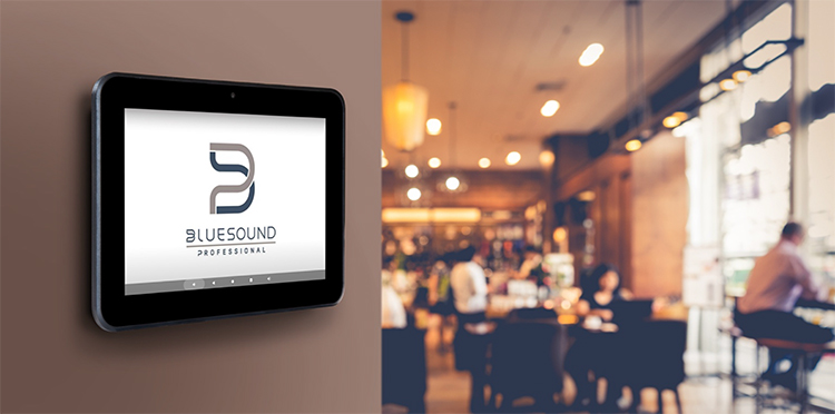 Bluesound Professional CP300 Wall Mount Control Panel showing off a splash screen of the Bluesound Professional logo while this wall mount control panel is situated inside a restaurant setting