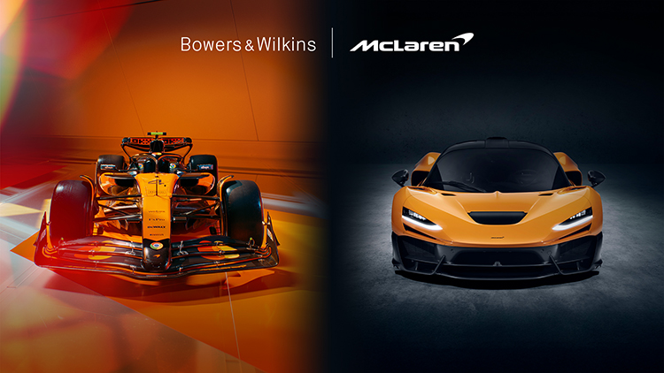 Digital promotional landscape banner showcasing the Bowers and Wilkins typographic logo in white alongside the McLaren typographic logo in white while underneath both of these logos is an orange/black decorative McLaren Formula 1 Team car on one half side of the banner with an orange/black McLaren W1 luxury supercar model on the other half side of the banner