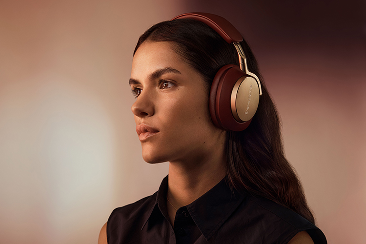 Woman wearing Bowers and Wilkins Px8 headphone (Royal Burgundy finish) looking away into the distance