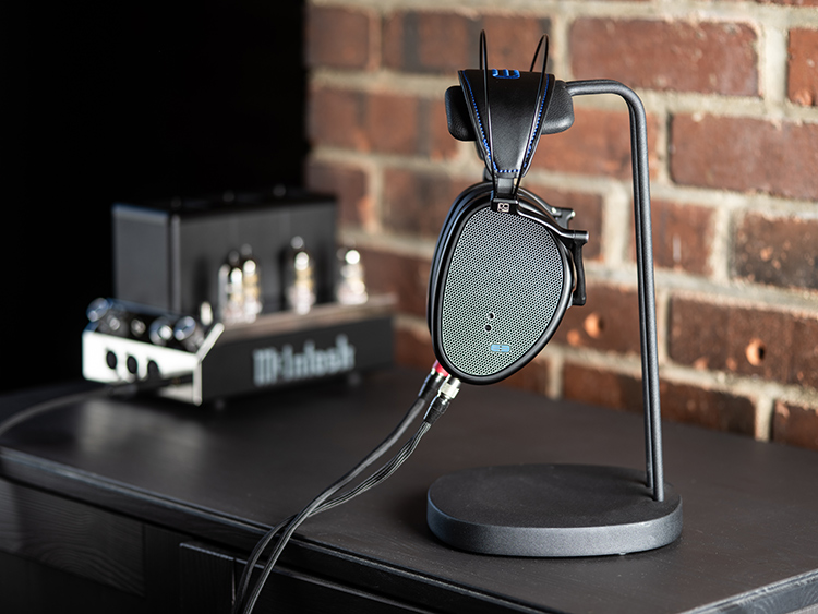 Dan Clark Audio E3 Closed Back Headphone Side View hanging on a small black pedestal nearby a McIntosh amplifier product model