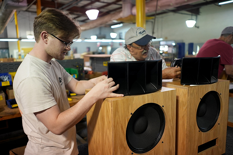 Two male worker employees working on assebmling the Klipsch + Ojas Limited Edition kO-R1 Horn Loudspeakers Spiral Red Oak Finish located within the Klipsch factory in Hope, Arkansas