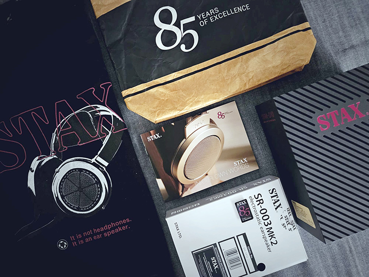 Left Angle View of STAX - 85 Years of Excellence special bundle containing several items such as a sweatshirt, bag, ebook, and two product giveaways