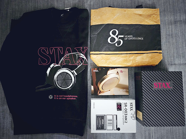 Top View of STAX - 85 Years of Excellence special bundle containing several items such as a sweatshirt, bag, ebook, and two product giveaways