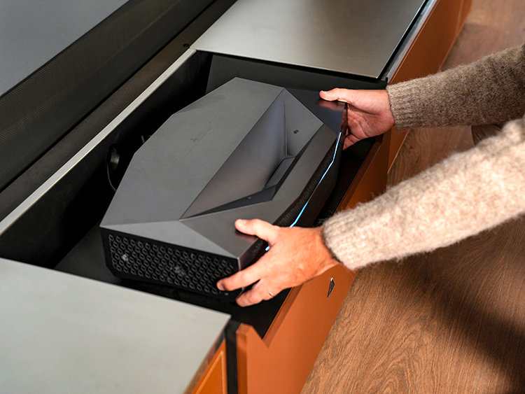 Person's hands holding onto and grabbing the sides of the AWOL Vision Aetherion 4K 200-Inch UST Projector