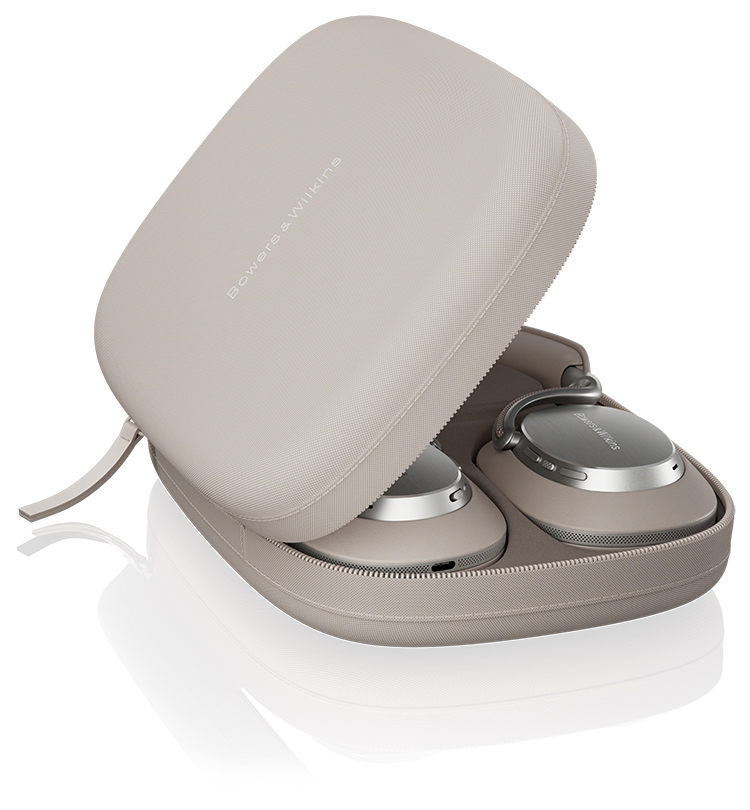 A portrait orientation photograph marketing promotional image display of the Bowers and Wilkins Px8 S2 Warm Stone color finish over-ear wireless headphones neatly folded and placed inside its matching, open, light-colored fabric carrying case; The word Bowers & Wilkins is visible on the inside top lid of the case and on the earcups