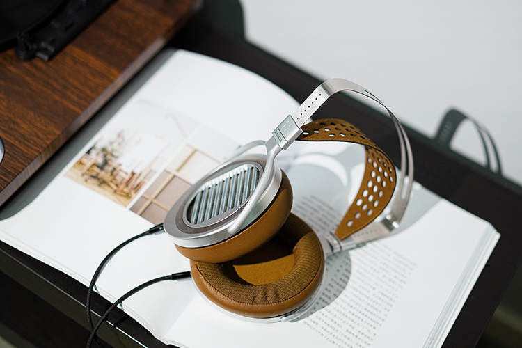 HIFIMAN SUSVARA UNVEILED Reference Open-Back Planar Headphone resting on top of open book pages