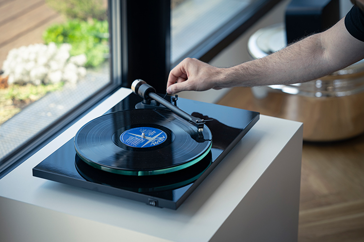 Person's arm adjusting the Pro-Ject T2 Super Phono Turntable/Built-in phono preamp Living Room View
