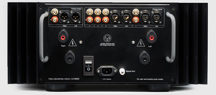 The Pass Labs INT-250 rear panel. Very nice binding posts with tightening clutches are used, along with top of the line connectors and switches. Inputs and outputs are offered either balanced or single ended. The very sturdy handles are essential to move the 105 lb. INT-250.