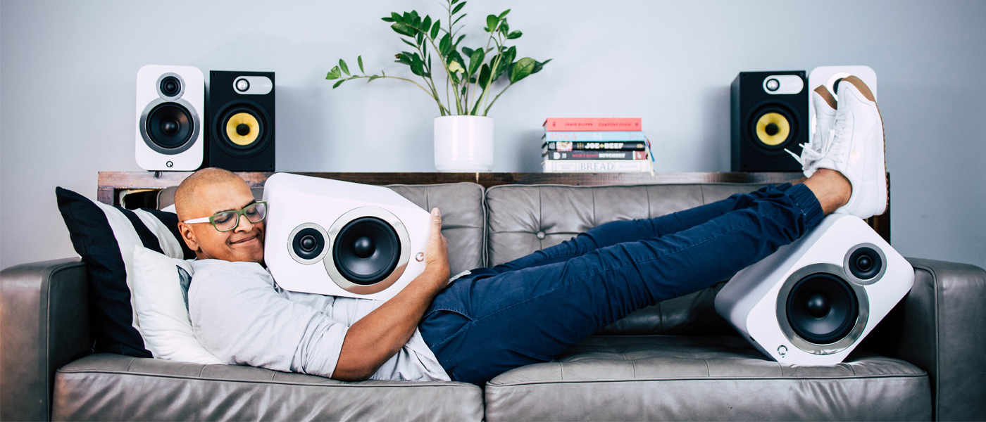 Man Laying on Couch Hugging Speaker