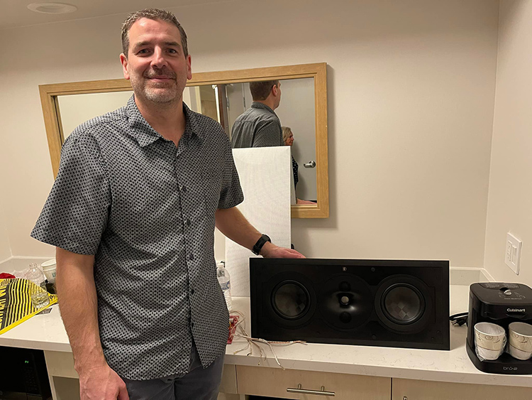 A representative from Perlisten Audio shows off a in-wall speaker at Florida Audio Expo 2022