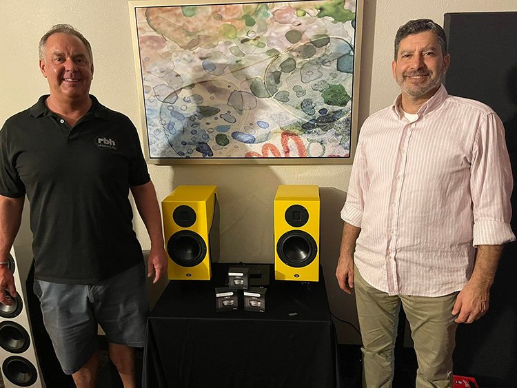 Two guys are proud to reveal and unveil the yellow PM-6 standmounted two-way monitor speakers from RBH Sound at Florida Audio Expo 2022