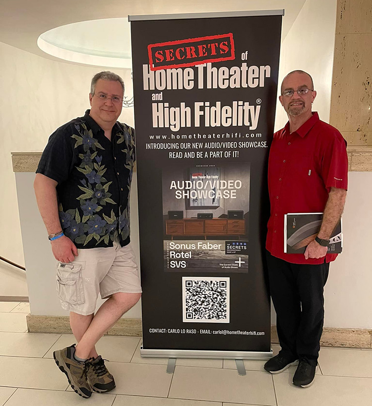 Carlo Lo Raso (left) and Chris Eberle (right) stand in front of the SECRETS banner at the Florida Audio Expo 2022