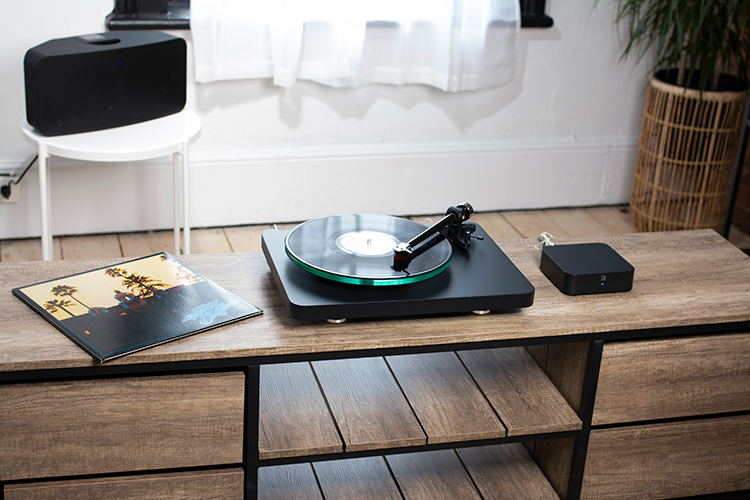 Bluesound HUB with turntable and PULSE 2i connected situated next to a music album