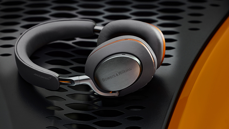 Bowers and Wilkins Px8 McLaren Edition Headphone (Galvanic Grey and Papaya Orange Finish) rested on top of the high-performance hybrid McLaren Artura supercar