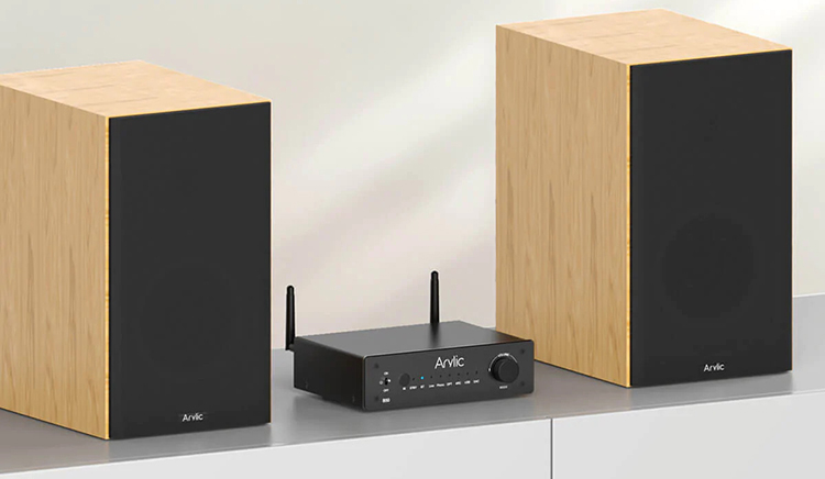Arylic B50 Bluetooth Stereo Amplifier with Audio Transmitter sits in between two Arylic wood finish bookshelf speakers on top of a long cabinet