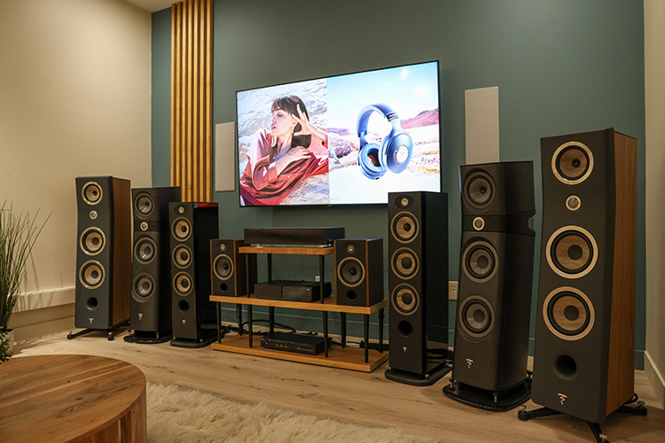 A close-up landscape photograph view of the Focal Powered by Naim loudspeaker products lined up at a curved angle in the showroom area of the retail space in Newport Beach